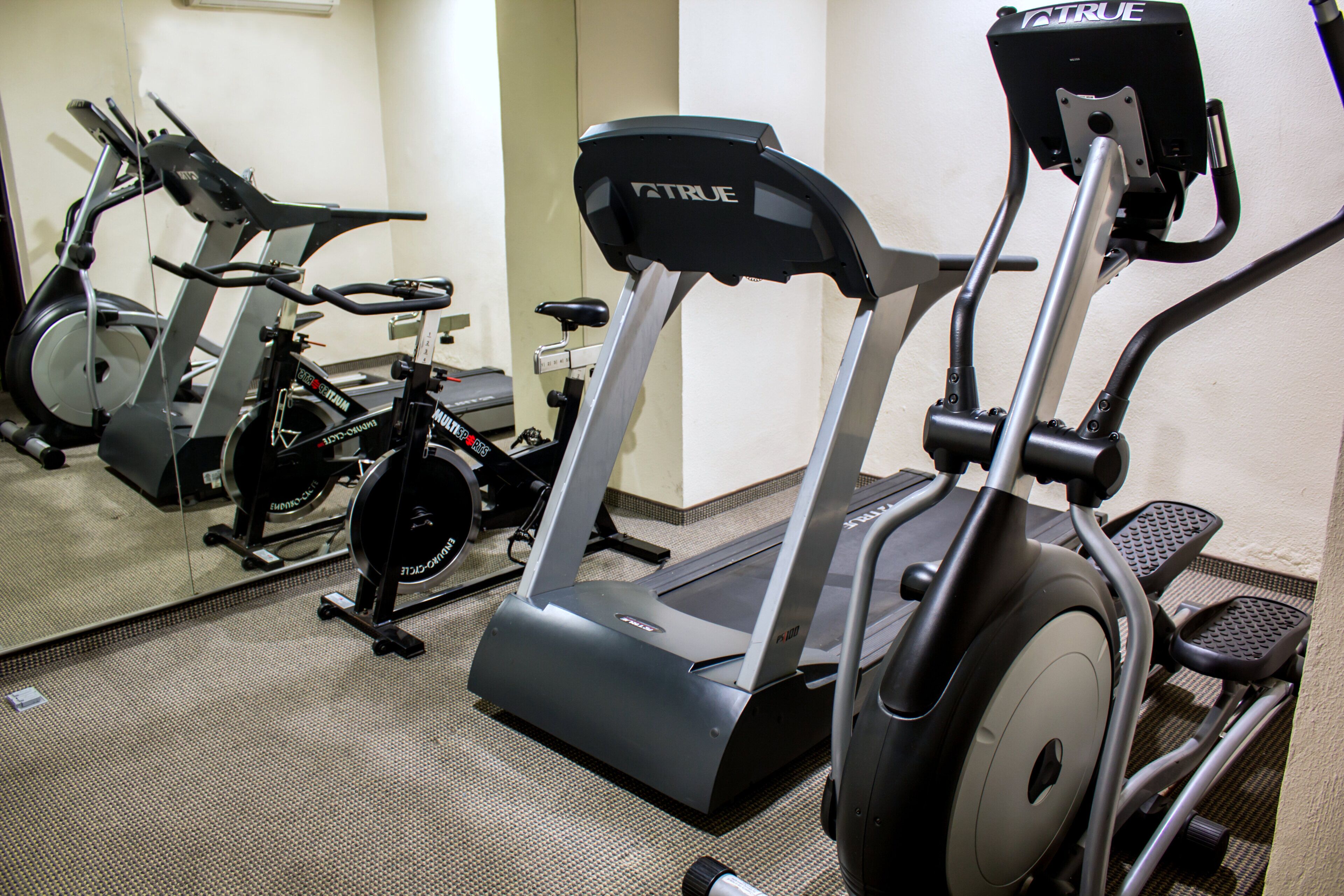 Een fitnessruimte met hometrainers en loopbanden.
