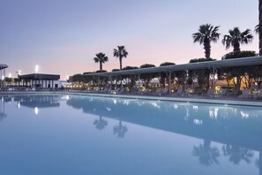 Een binnenzwembad, 2 buitenzwembaden en parasols bij het zwembad