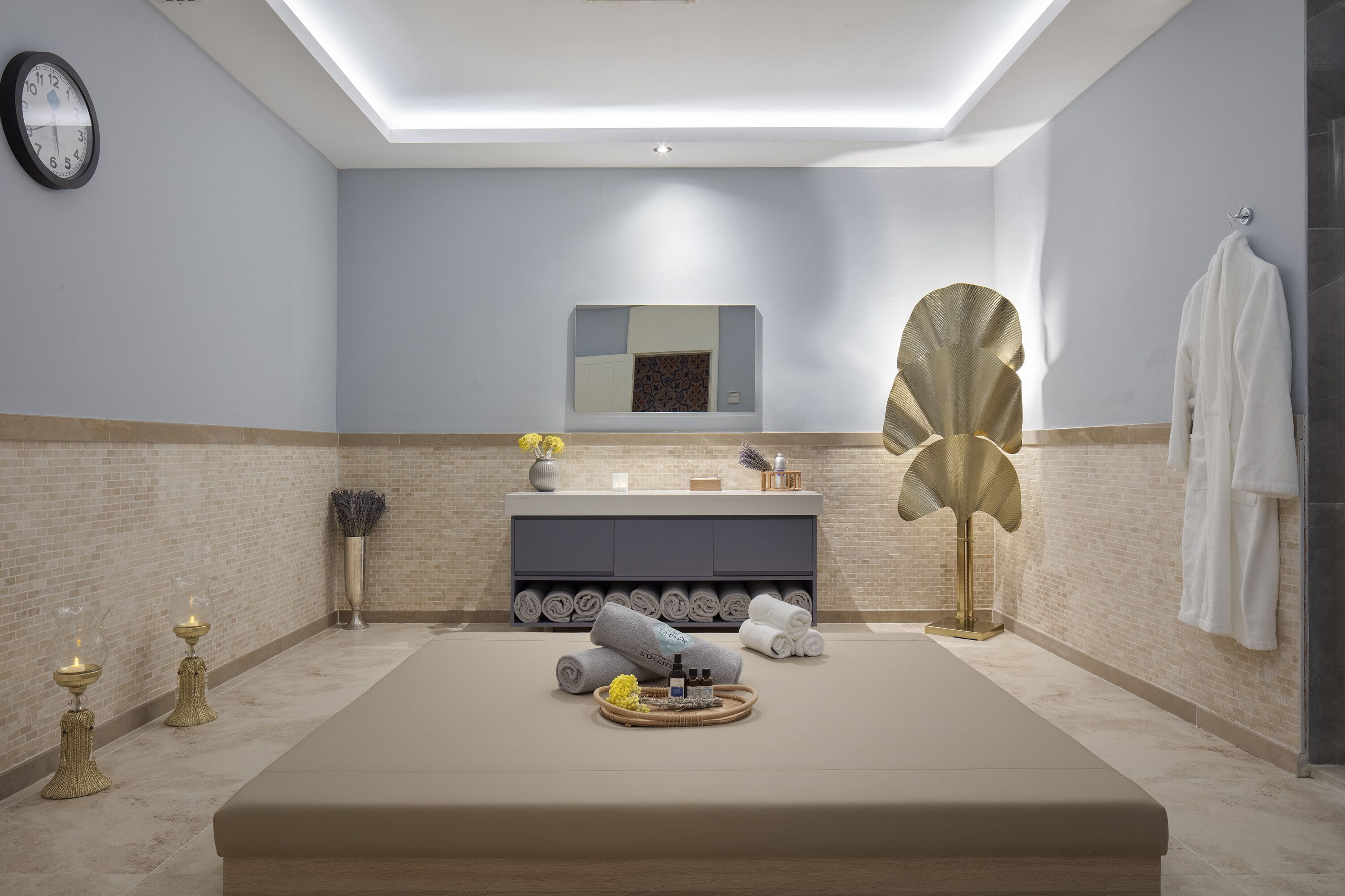 Ein modernes Badezimmer mit einer großen Badewanne, einem Waschtisch mit Spiegel und einem Handtuchhalter.