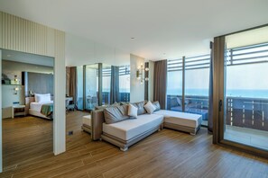 Una habitación de hotel moderna con una cama grande, un sofá, un comedor y un balcón con vistas.