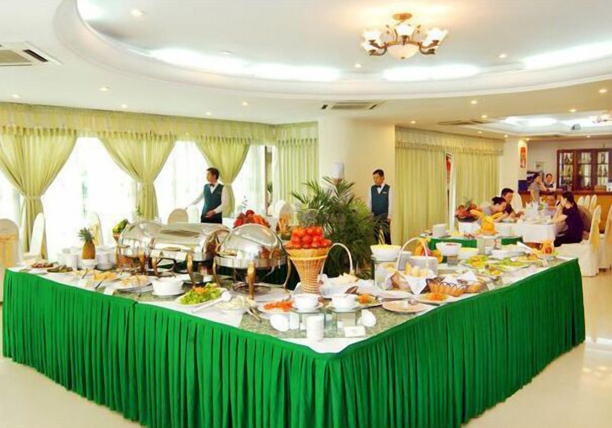 A buffet setup with various food items and a green tablecloth.