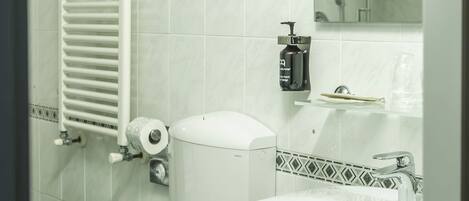 A bathroom with a toilet, sink, and towel rack.