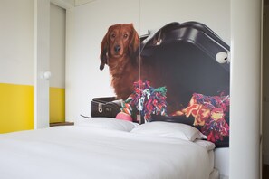 A bed with a colorful artwork of a dog and a guitar. - Qbic Hotel Amsterdam WTC (Amsterdam)