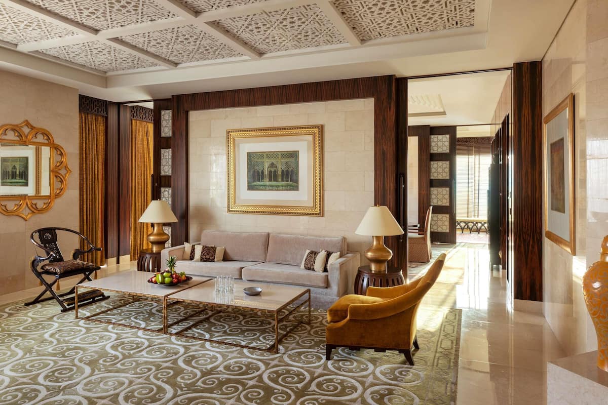 A spacious living area with a sofa, armchairs, a coffee table, and decorative lamps.