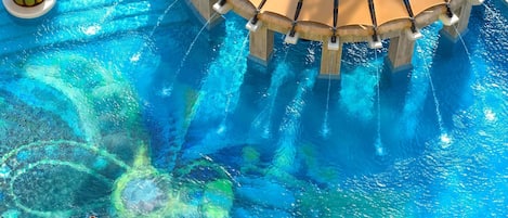 Una piscina al aire libre, sombrillas, sillones reclinables de piscina