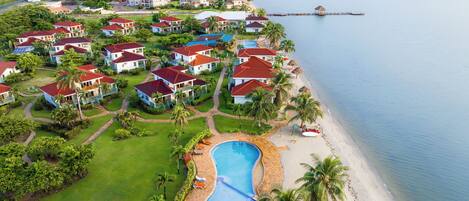 A resort with multiple buildings, a swimming pool, and a beach.