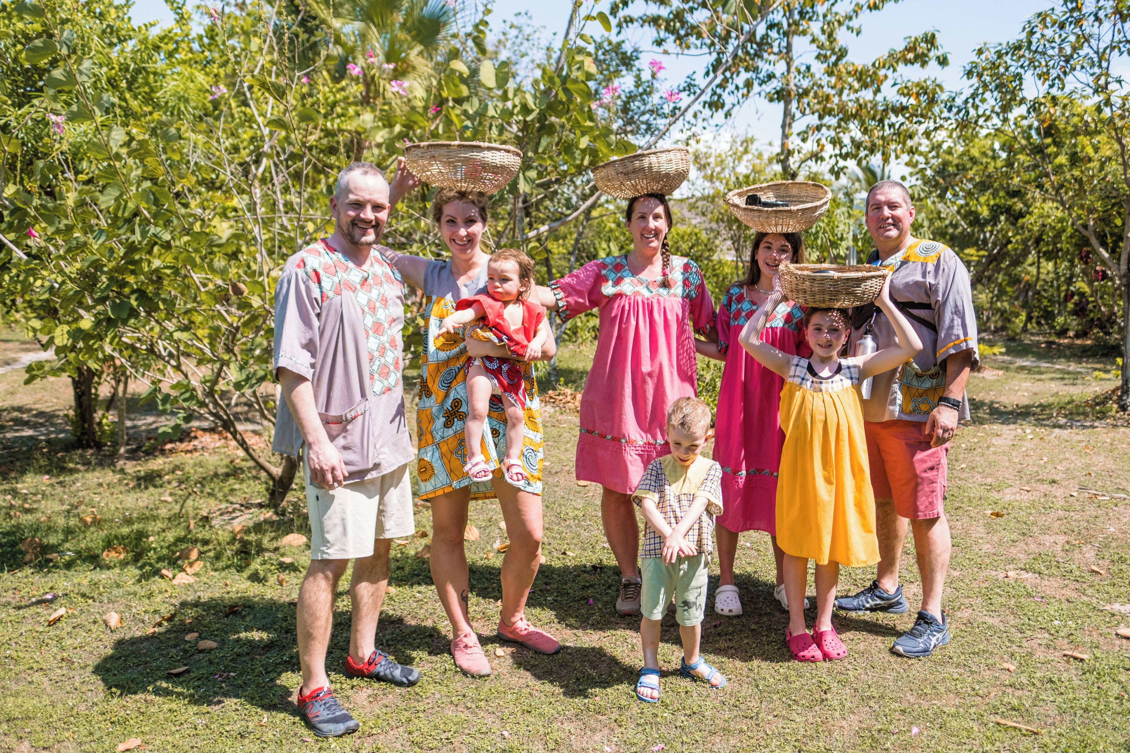 A group of people in an outdoor setting with trees and grass.