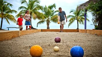 Una zona de playa arenosa con palmeras y una estructura de madera.
