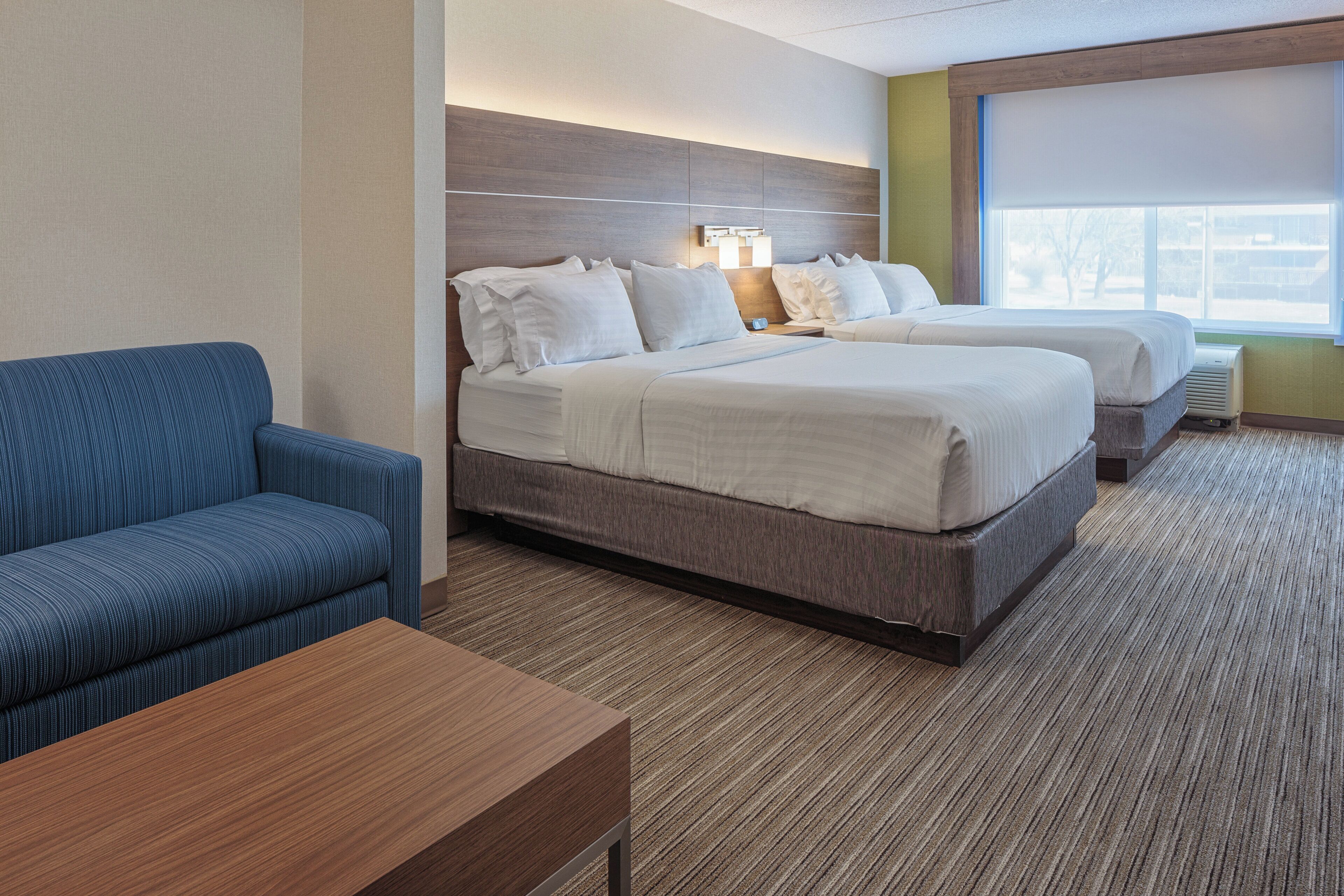Una habitación de hotel con cama, sofá y mesa.