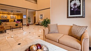 A spacious lobby with a sofa, armchairs, a coffee table, and a TV screen. - Best Western Route 66 Glendora Inn (Glendora)
