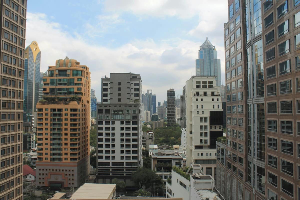 Un paisaje urbano con edificios altos, incluyendo un edificio destacado con un diseño arquitectónico único y otro con fachada de vidrio moderna.
