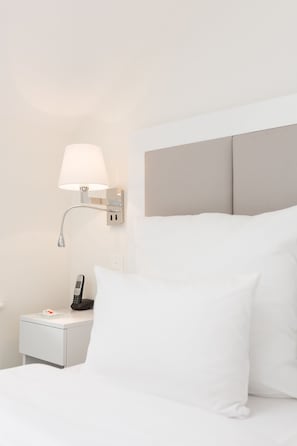 A hotel room with a bed, white bedding, a nightstand with a lamp, and a telephone. - Hotel Brandenburger Tor Potsdam (Potsdam)