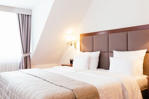 Ropa de cama de alta calidad y caja de seguridad en la habitación 