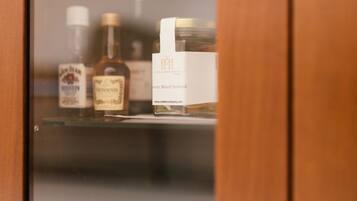A wooden door with a mirror reflecting a shelf containing bottles and a box.