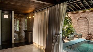 Relax in a tranquil setting with a pool area, brick wall, and seating space.