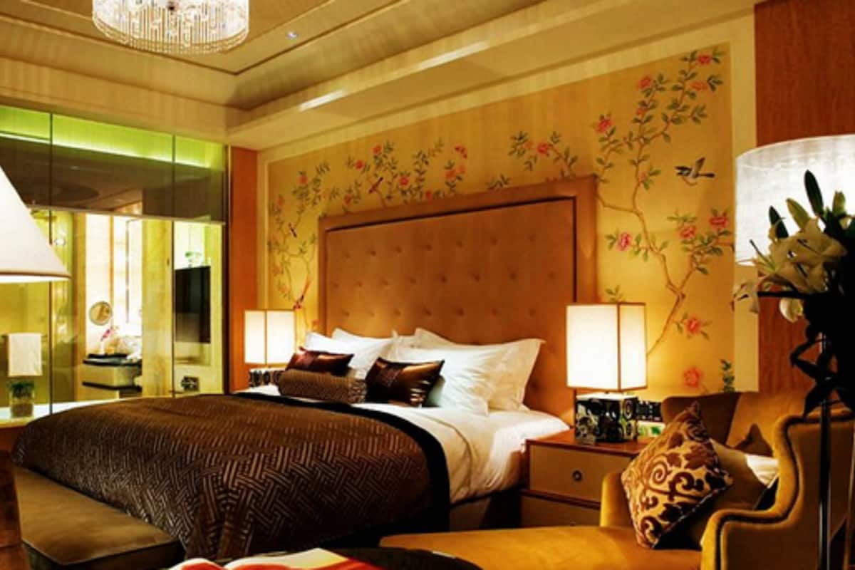 A hotel room with a large bed, two bedside tables, a chair, and a mirror.