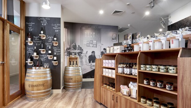 A restaurant interior with wooden barrels, a chalkboard menu, and shelves of jars. - RACV Goldfields Resort (Creswick)