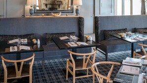 A restaurant with a high ceiling, wooden beams, and a central seating area with a large painting above. Tables are set with menus, glasses, and cutlery. - The Sebel Pinnacle Valley Resort (Merrijig)