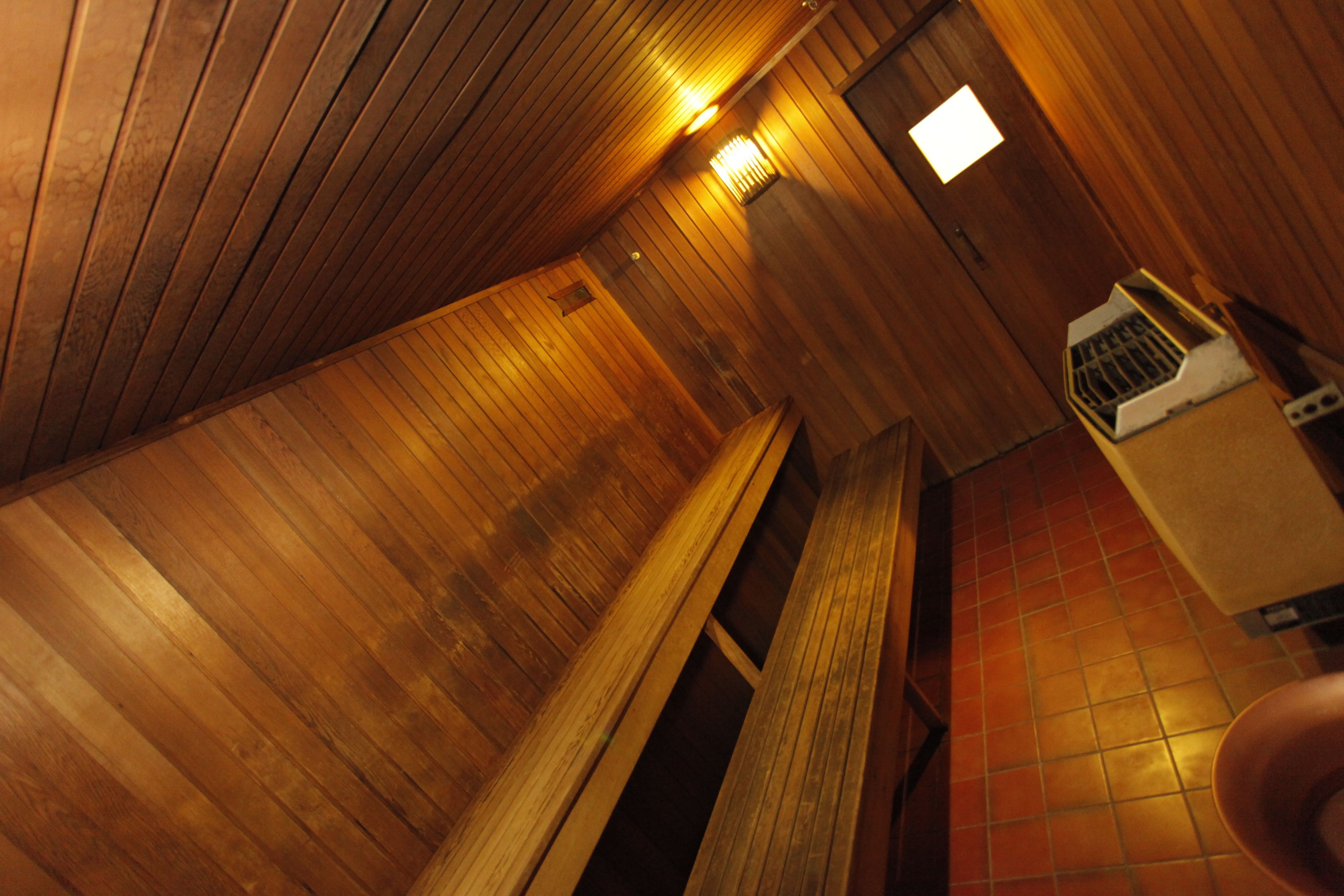 A sauna room with wooden walls and a tiled floor.