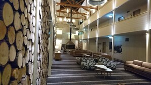 A spacious lobby with a high ceiling, a fireplace, and a patterned wall. - The Sebel Pinnacle Valley Resort (Merrijig)