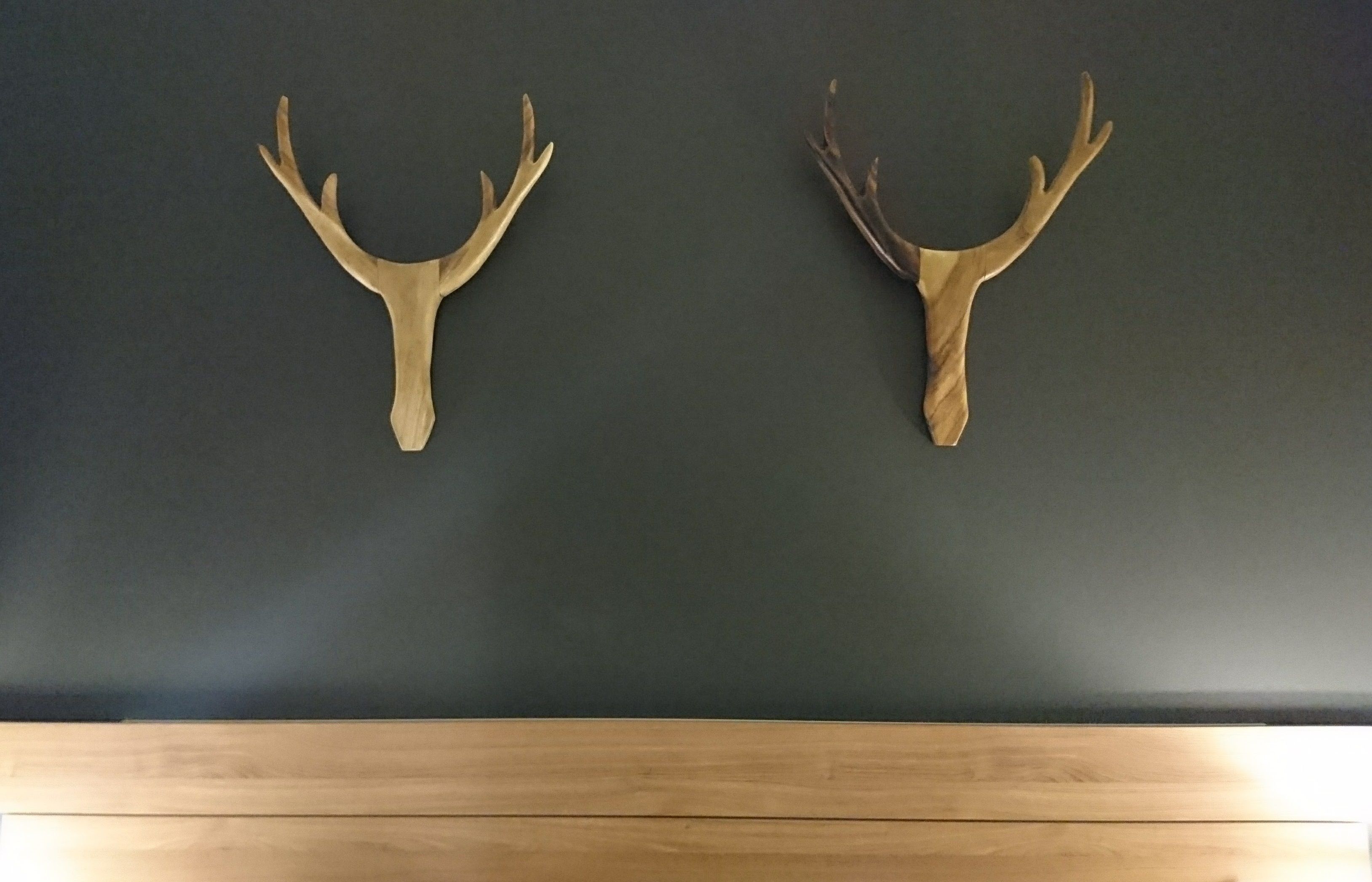 Dos astas de madera montadas en una pared oscura.