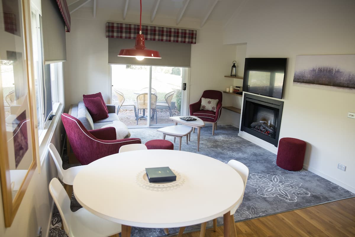 A cozy living room with a fireplace, a dining table, and comfortable seating.