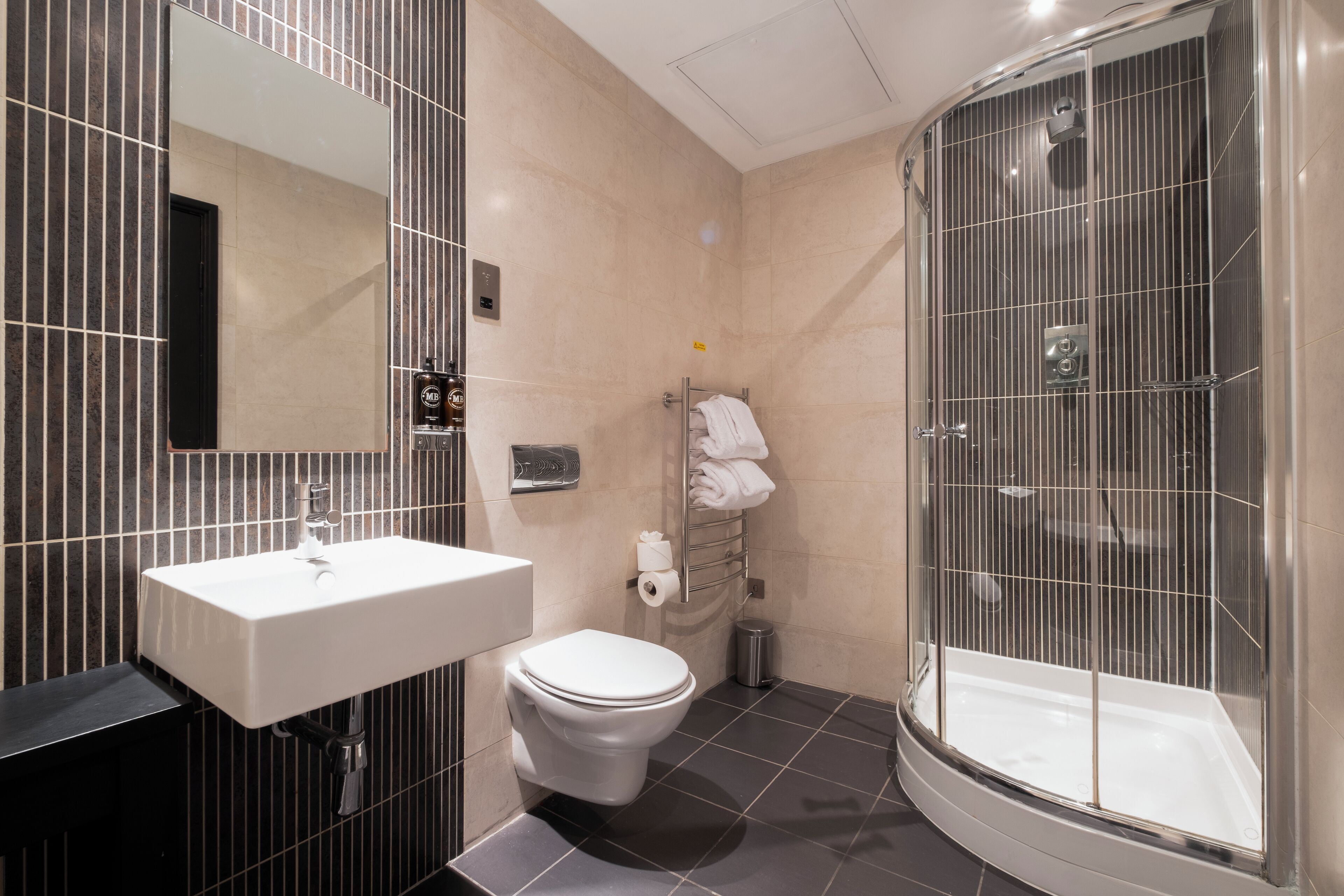 A modern bathroom with a sink, toilet, and glass-enclosed shower.