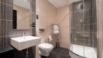 A modern bathroom with a sink, toilet, and glass-enclosed shower.