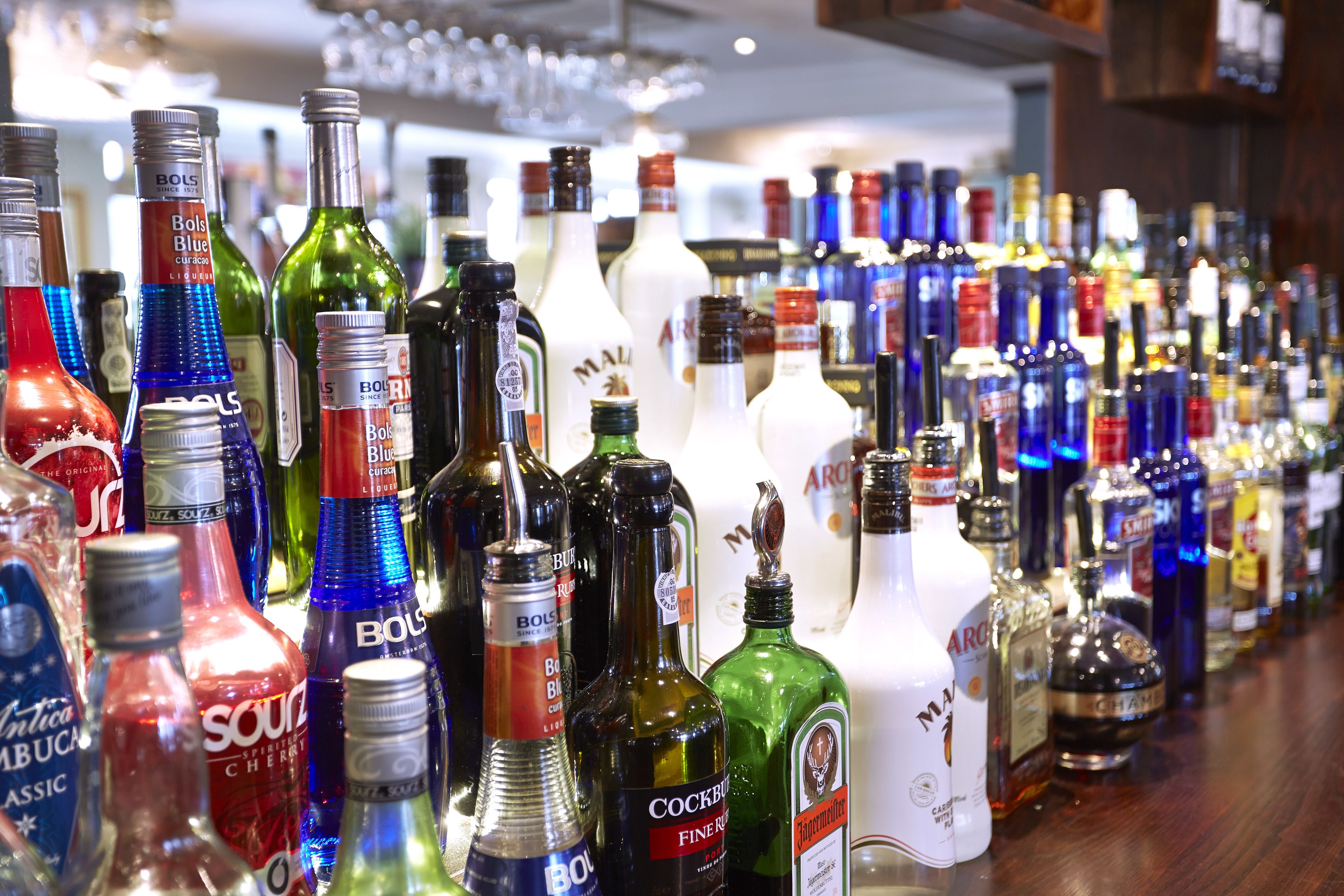 A variety of liquor bottles displayed on a bar counter.