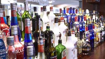 A variety of liquor bottles displayed on a bar counter.