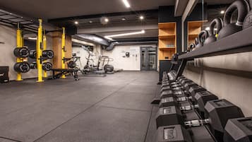 Una palestra con attrezzature per l'allenamento con i pesi, tapis roulant e macchinari cardio.