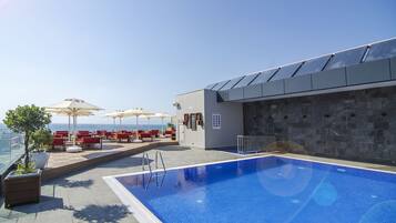Piscine extérieure, parasols de plage, chaises longues