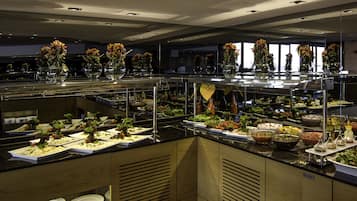 Een buffetopstelling met verschillende gerechten en decoratieve bloemen.