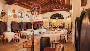 Un restaurante con decoración rústica, que presenta barriles de madera, mesas y arcos.