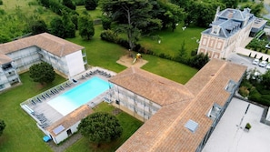 Une propriété résidentielle dotée d’une piscine, d’un espace de jeux pour enfants et d’un grand jardin.