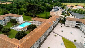 Un grand bâtiment doté d’une piscine, de nombreux balcons et d’une cour intérieure.