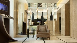 A modern hotel lobby with a reception desk, seating area, and decorative vases. - TURIM Restauradores Hotel (Lisbon)