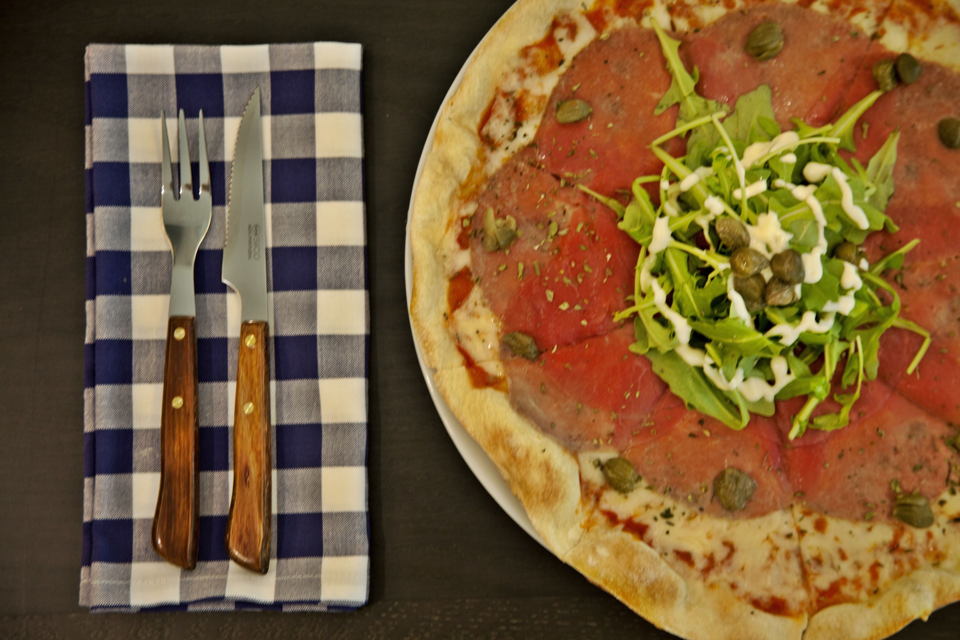 Une pizza garnie, posée sur une surface sombre.