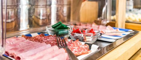 A buffet with various meats and condiments.