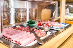 Un bufé con diferentes carnes y salsas.