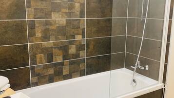 A modern bathroom with a bathtub, a shower, and a sink.
