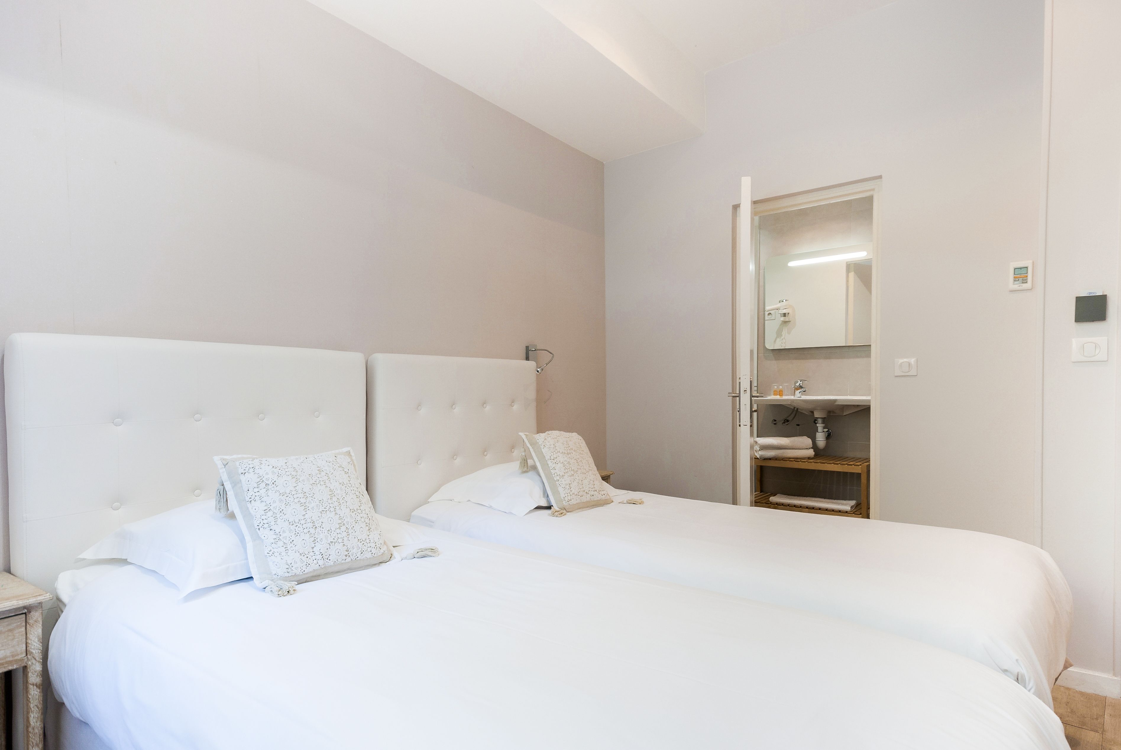 A double bed with a tufted headboard, two pillows, and a bedside table.