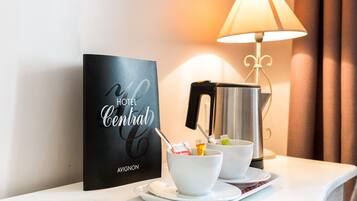 A hotel sign, a coffee maker, and a breakfast setup on a table.