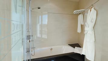 Ein modernes Badezimmer mit einer gläsernen Duschkabine, einer Badewanne und einer Glastür.