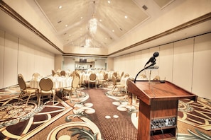 A conference room with a podium, tables, and chairs arranged for a meeting.