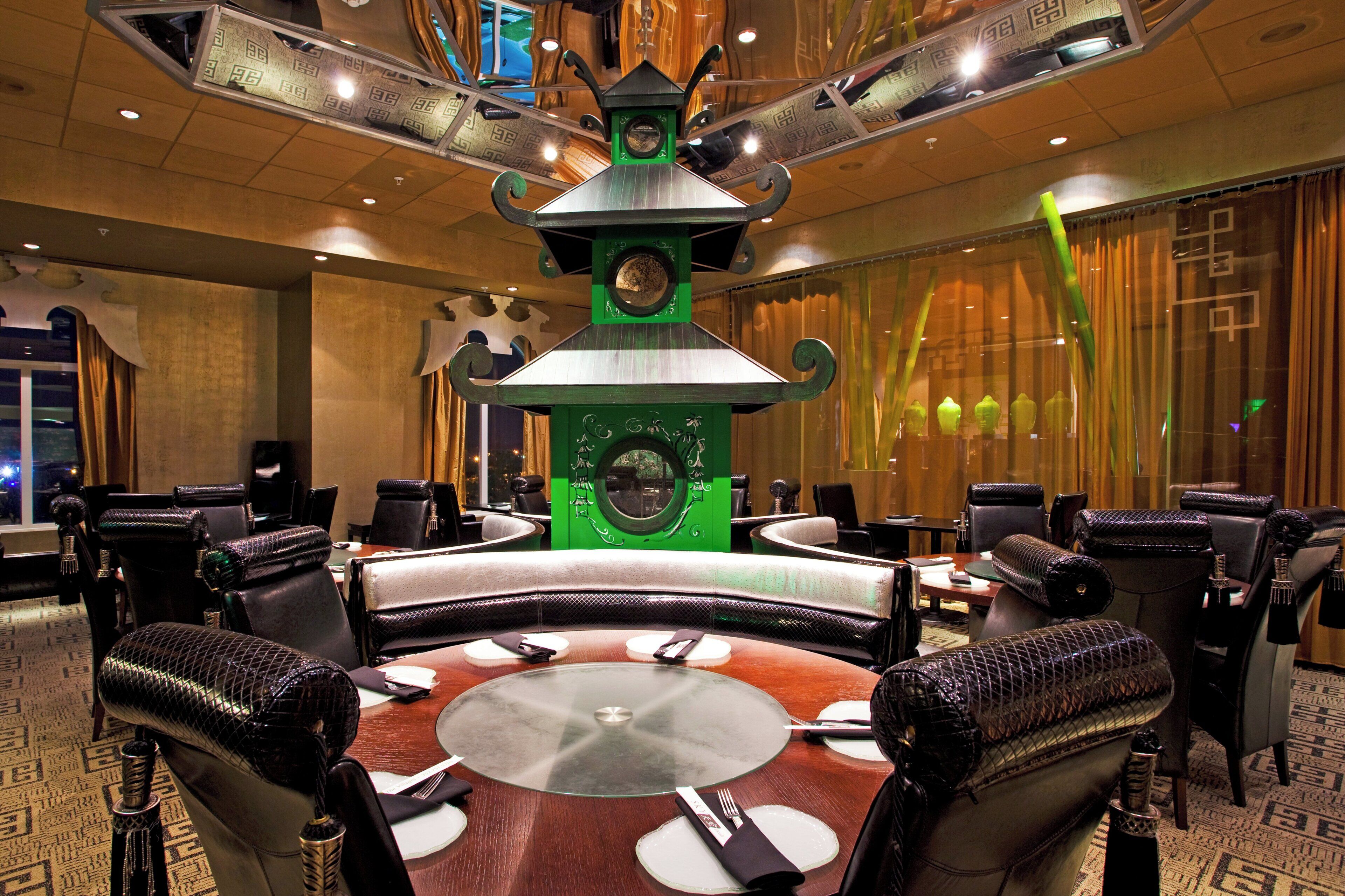 A conference room with a central table, surrounded by chairs, and a decorative clock on the wall.
