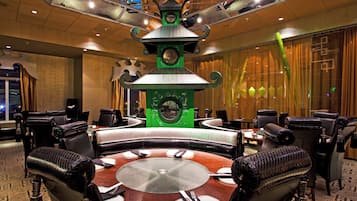 Une salle de conférence avec une table centrale, entourée de chaises, et une horloge décorative au mur.