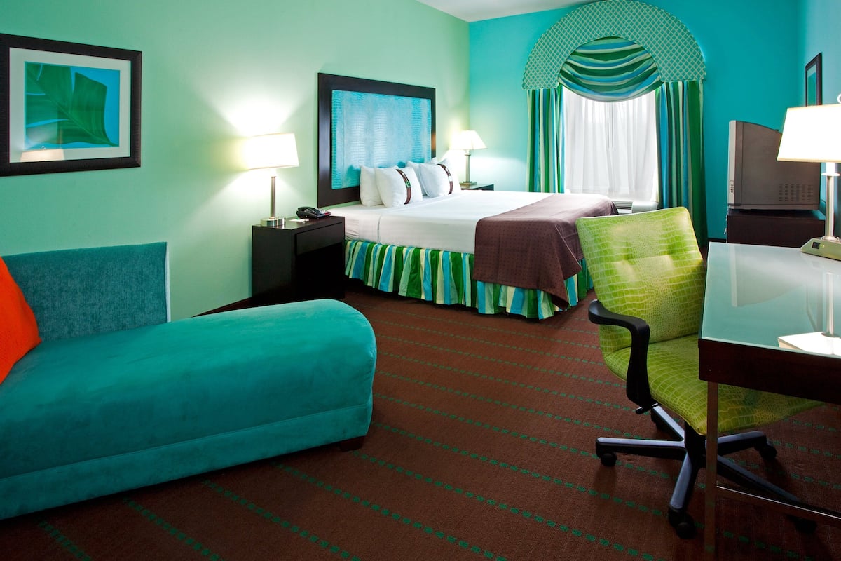 Ein Hotelzimmer mit einem Bett, einem Schreibtisch, einem Sessel und einem Sofa.