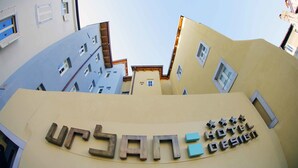 A hotel sign with "URBAN HOTEL DESIGN" and a modern building facade with multiple windows and balconies. - Urban Hotel Design (Trieste)