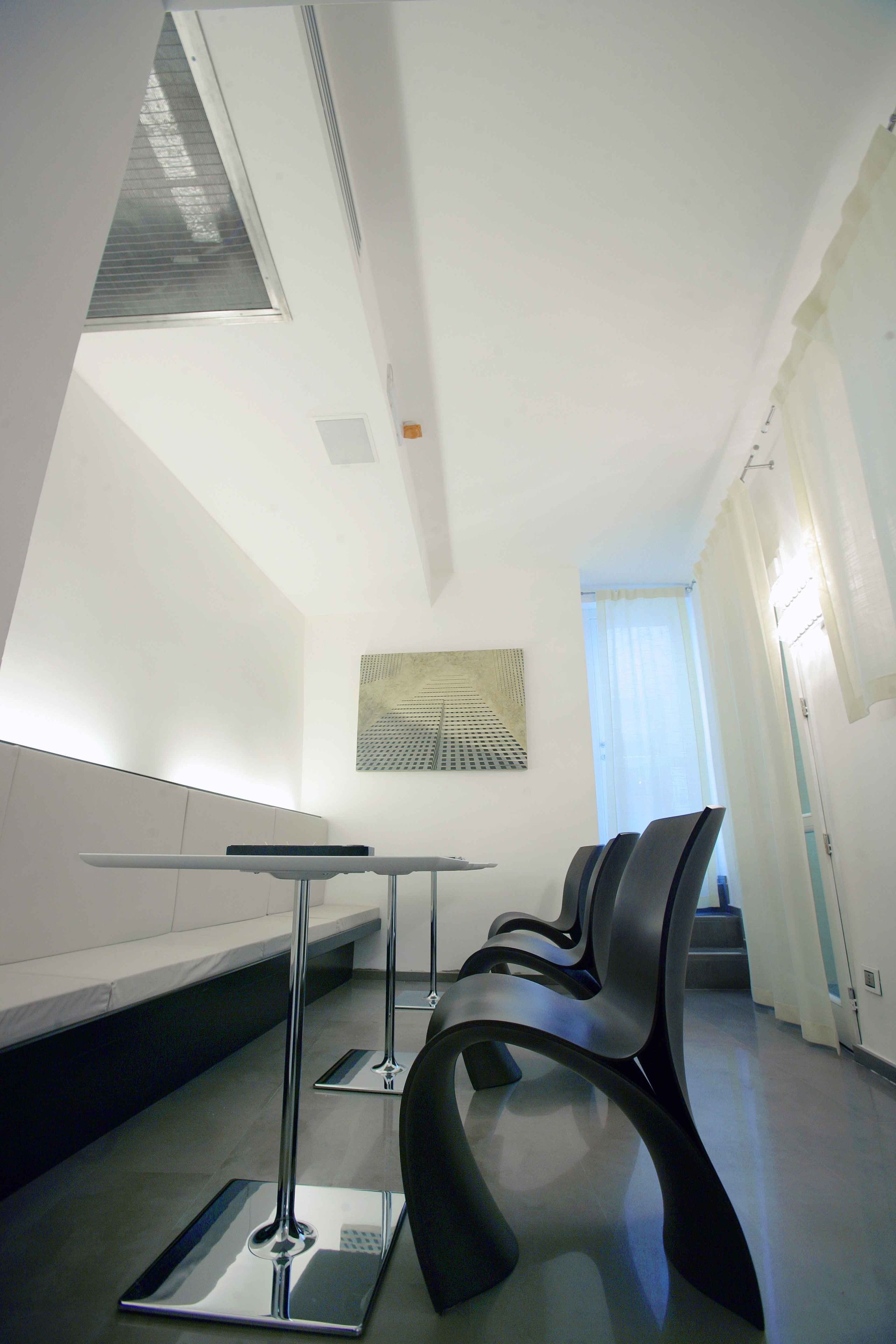 Un área de espera moderna con un banco, una mesa y una silla.